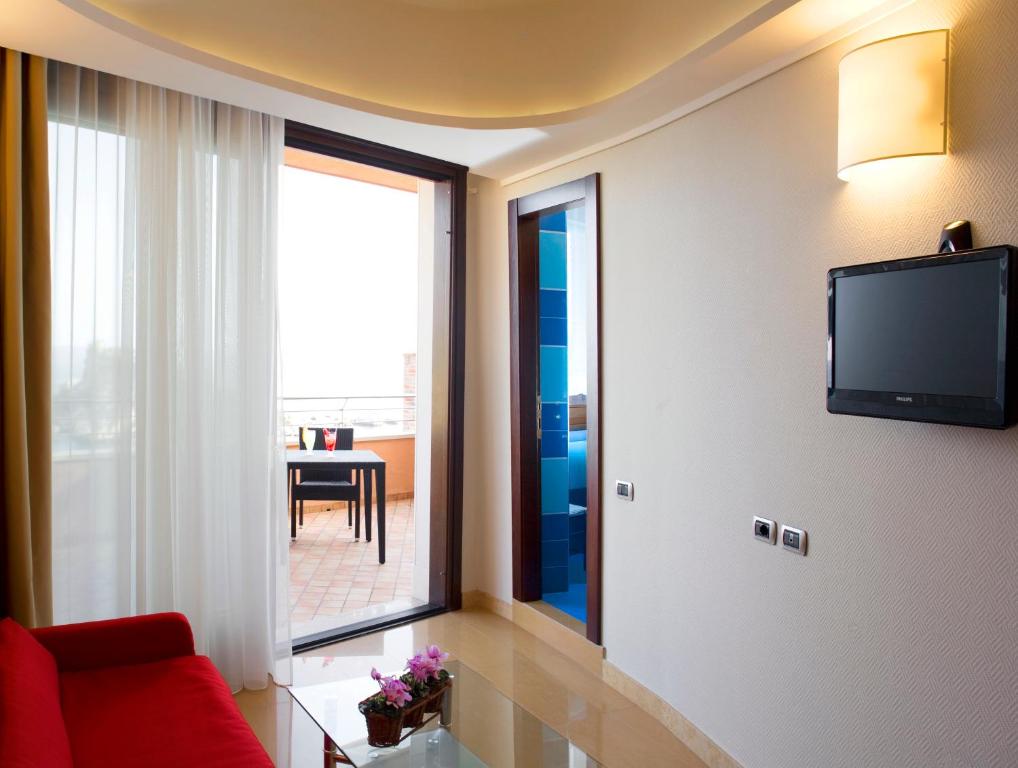 a living room with a red couch and a large window at Taormina Panoramic Hotel in Taormina