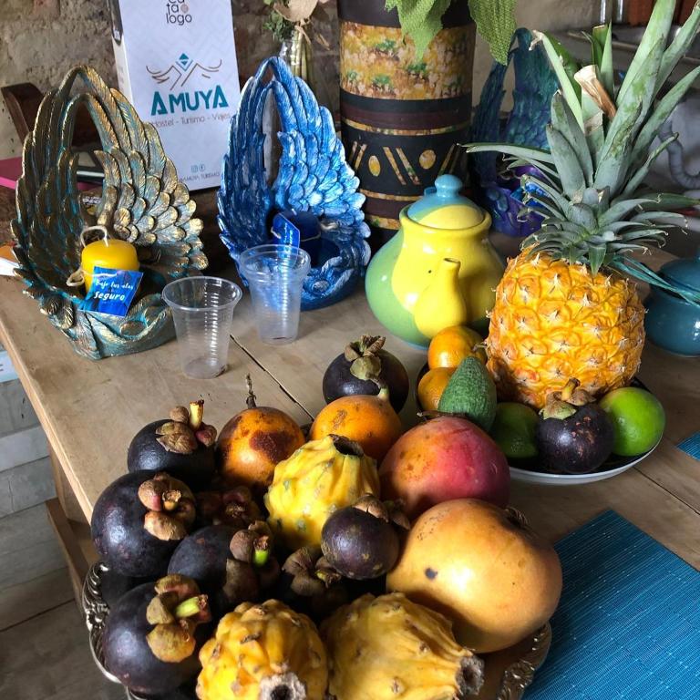 un tavolo con un mucchio di frutta sopra di Amuya Hostel a Chiquinquirá