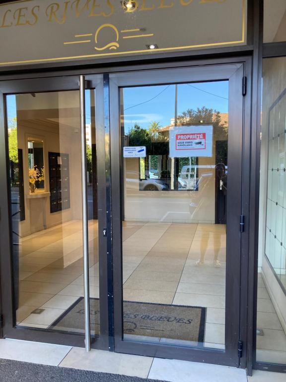 une entrée à un magasin avec portes en verre tournantes dans l'établissement 2 pièces 55 m2 Juàn les pins, à Juan-les-Pins