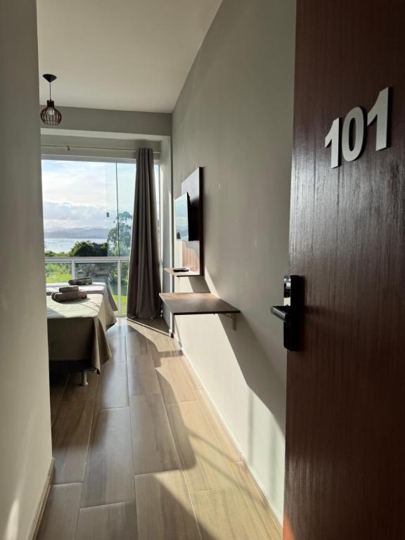 une chambre avec une porte et une chambre avec vue dans l'établissement Apartamento de frente para lagoa -Ap 101, à Laguna