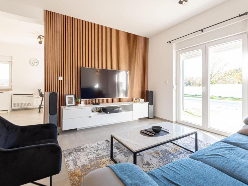 a living room with a blue couch and a tv at Holiday Home Iva - Three Bedroom Holiday Home in Šibenik