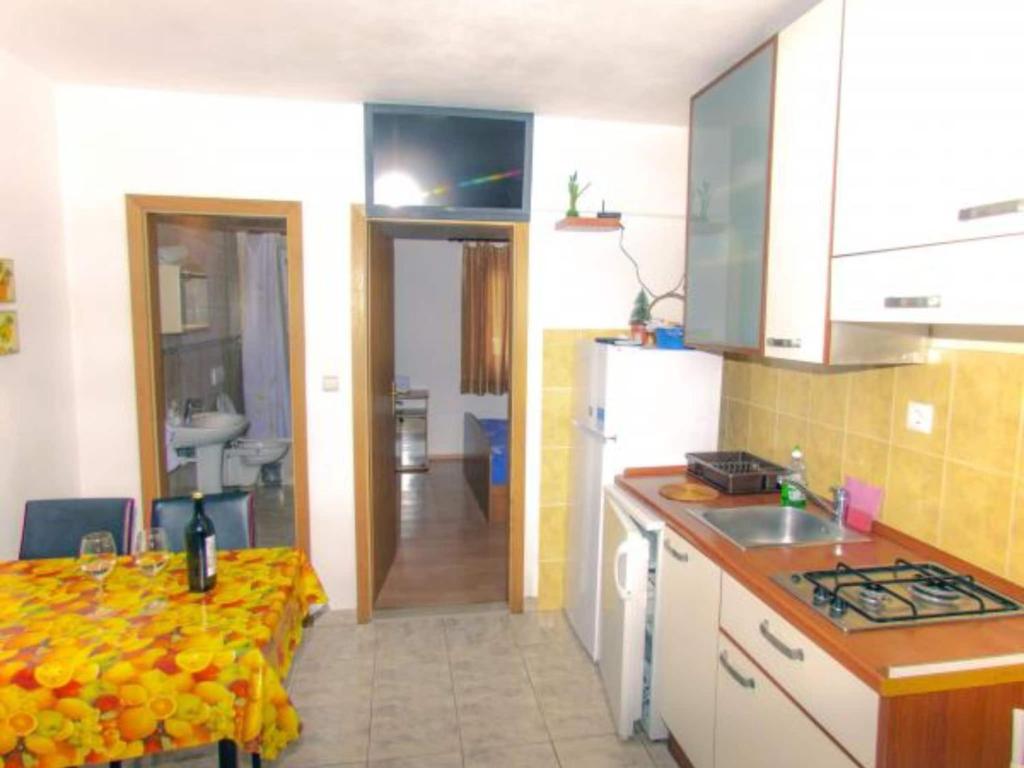 a kitchen with a table and a counter top at Beachfront Apartments Pla a - One Bedroom Apartment A3 in Ivan Dolac