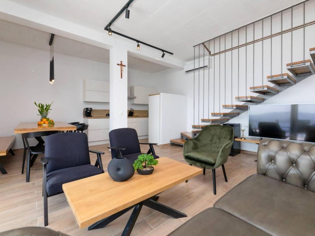 a living room with chairs and a table and stairs at Spectacular Bol Island Sea View Villa with Pool - Four Bedroom Villa with Pool in Bol