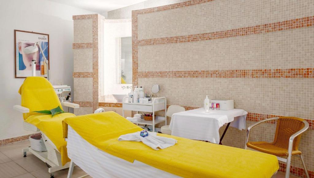 a therapy room with a yellow chair and a table at Golden Lotus Hotel in Kemer
