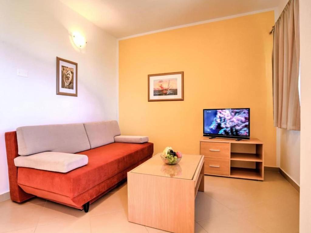 a living room with a couch and a tv at Wonderful Brsec Apartments with Sea View and Shared Pool - Standard One Bedroom Apartment in Brseč