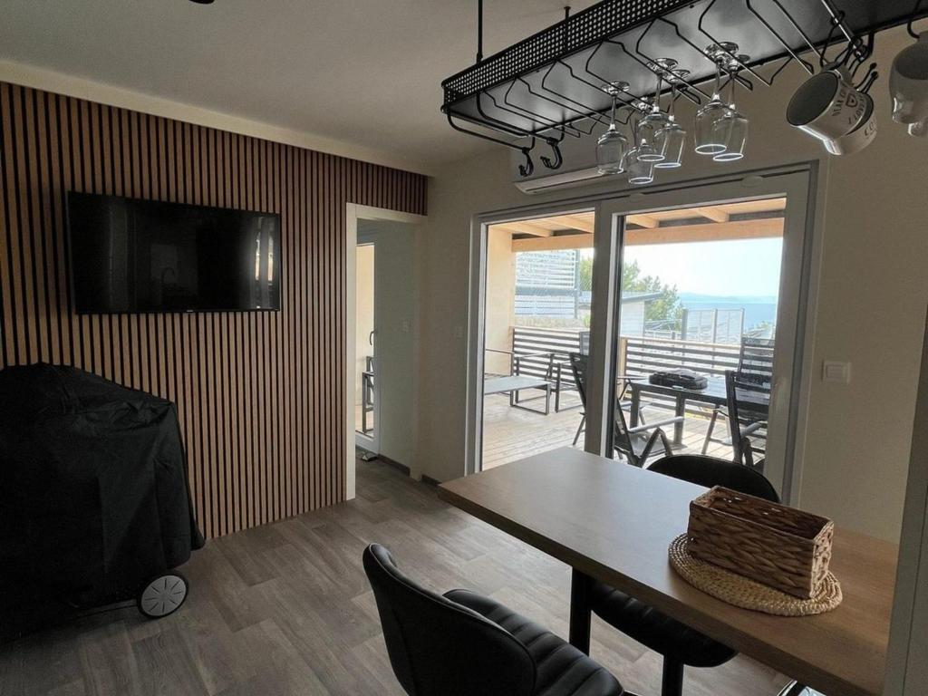 een eetkamer met een tafel en stoelen en een balkon bij Two Bedroom Mobile Home with Terrace and Sea View in Drage