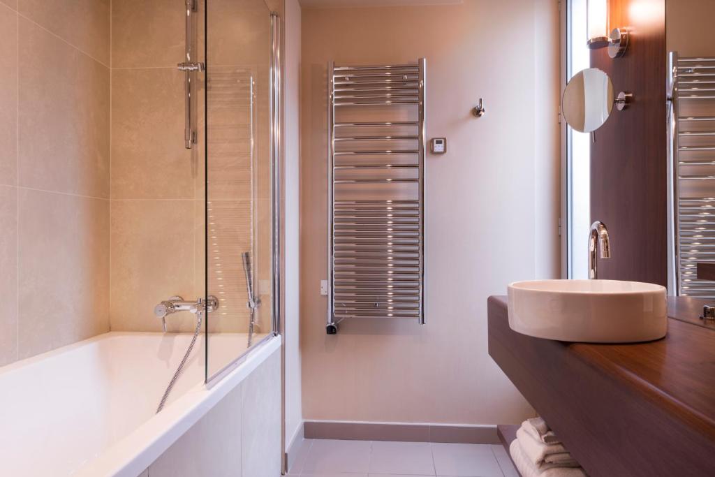 a bathroom with a sink and a shower and a tub at Hôtel La Bourdonnais by Inwood Hotels in Paris
