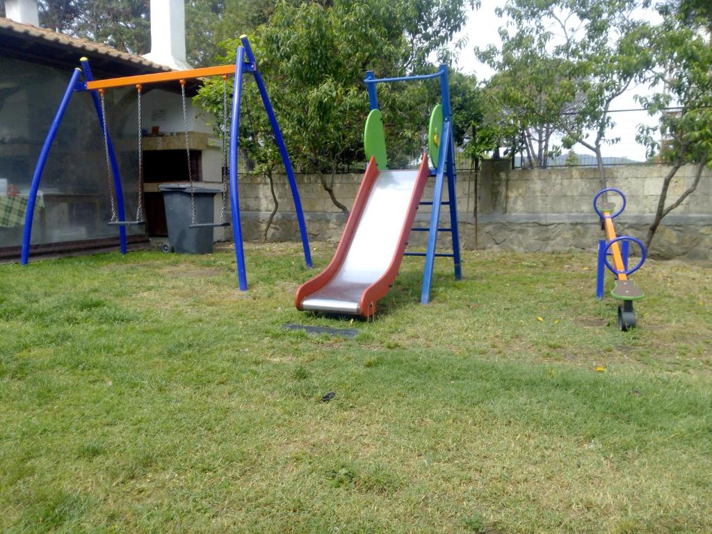 a playground with a slide in a yard at Haus Platanos Apartments & Bungalows by the Sea in Vourvourou