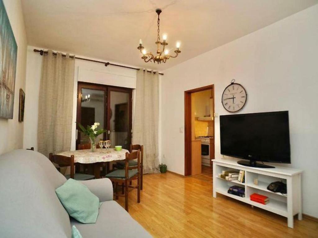 a living room with a flat screen tv and a table at Three Bedroom Apartment with Terrace in Seget Vranjica