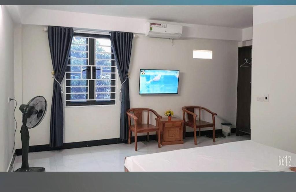 une chambre avec un lit et deux chaises et une fenêtre dans l'établissement Hotel Phương Anh bá thiện 2 vĩnh phúc, à Trung Mậu