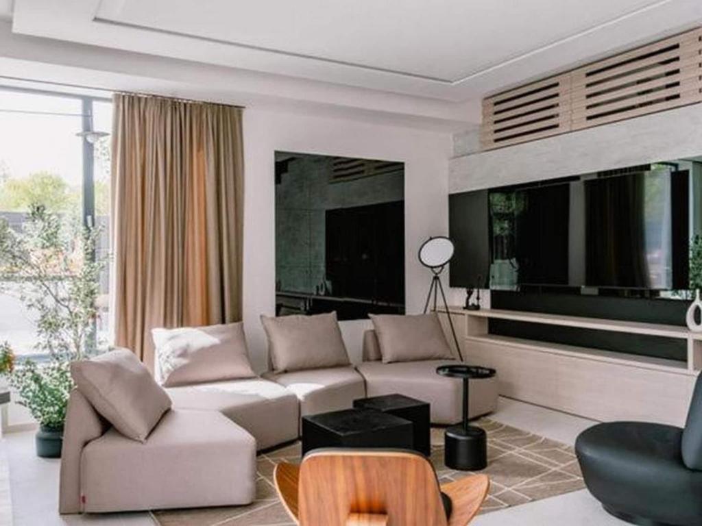 a living room with a white couch and a chair at Four Bedroom Villa with pool in Vodice