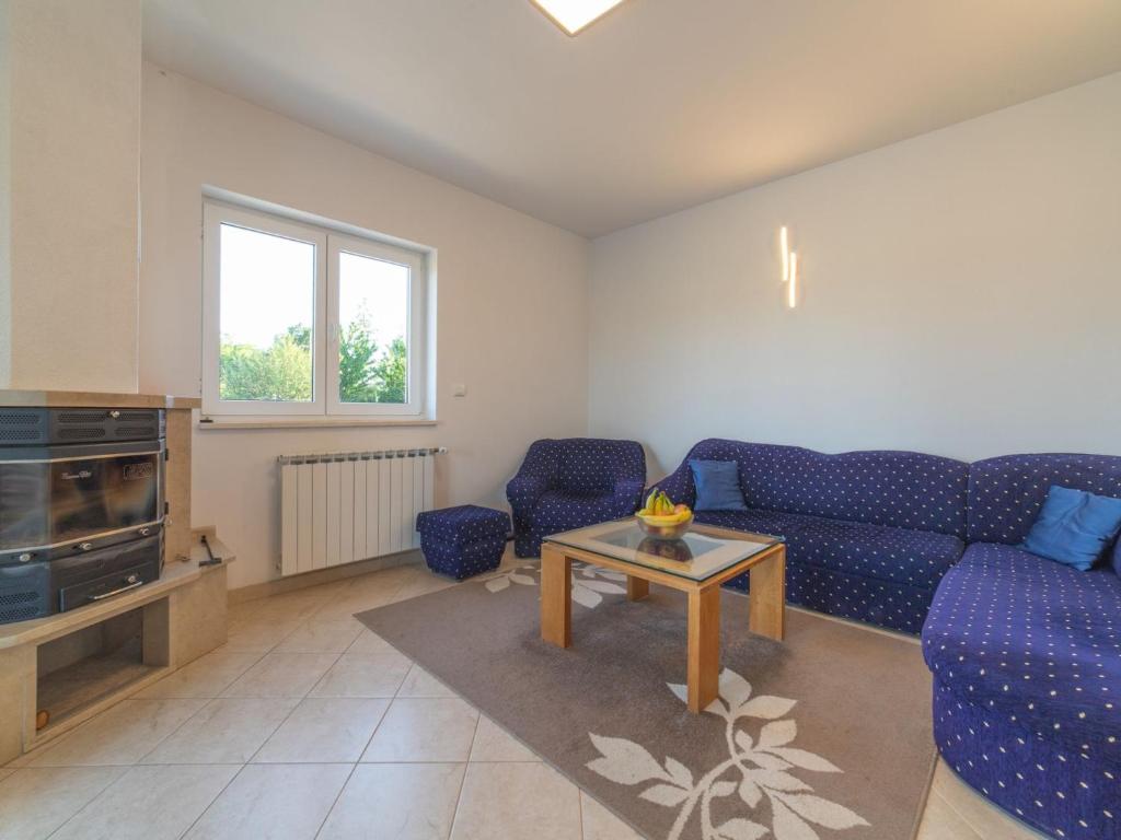 a living room with a blue couch and a tv at Idyllic Getaway Lovrec Villa with Pool - Five Bedroom Villa with Pool in Lovreć