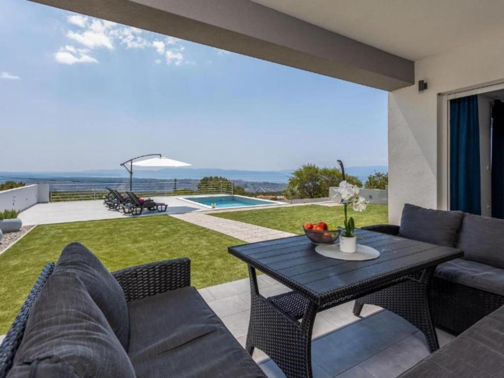 a living room with a couch and a table on a patio at Villa Fran - Four Bedroom Villa with Private Pool in Šmrika