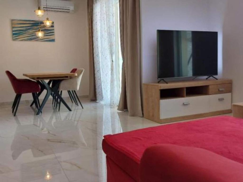 a living room with a television and a dining room table at Villa Tamaris - Two Bedroom Holiday Home with Terrace and Swimming pool in Mali Drvenik