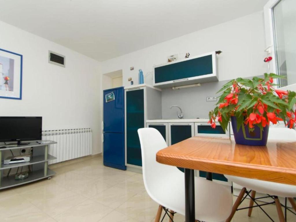a kitchen with a wooden table and a blue refrigerator at Apartment Juri i Kor ula - One Bedroom Apartment with Terrace in Korčula