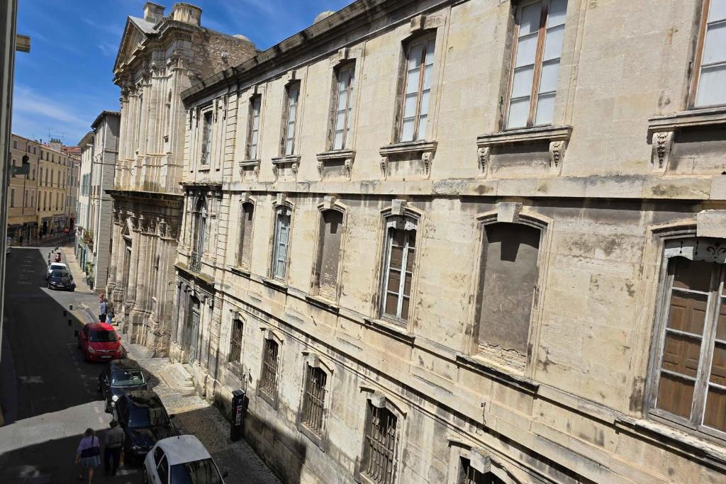 un vieux bâtiment sur le côté d'une rue dans l'établissement Charming studio in the crest, à Nîmes