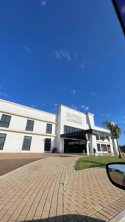 a large white building with a sign on it at Hotel Alvorada - Trindade do Sul in Trindade