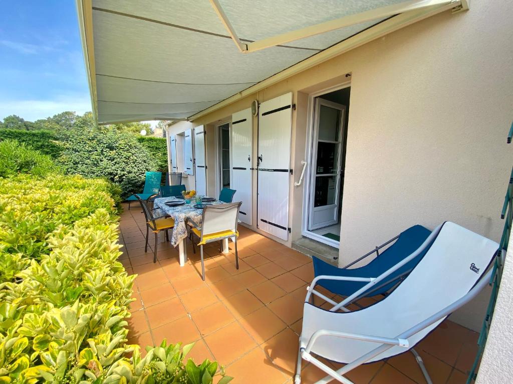 une terrasse avec des chaises et une table sur une maison dans l'établissement Maison rénovée avec jardin, 2 chambres, WiFi, à 500m de la mer - Brétignolles-sur-Mer - FR-1-231-320, à Bretignolles-sur-Mer