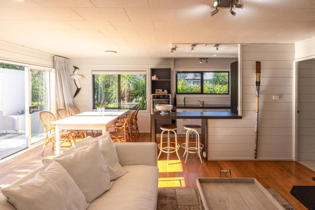 ein Wohnzimmer mit Sofa und Tisch in der Unterkunft Viletta Hauraki by Waiheke Pure in Waiheke Island