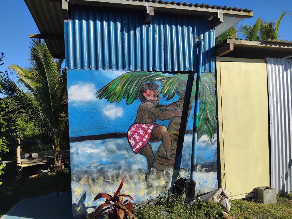 une peinture d'une femme sur le côté d'un bâtiment dans l'établissement CORAL Retreat, à Rewasau