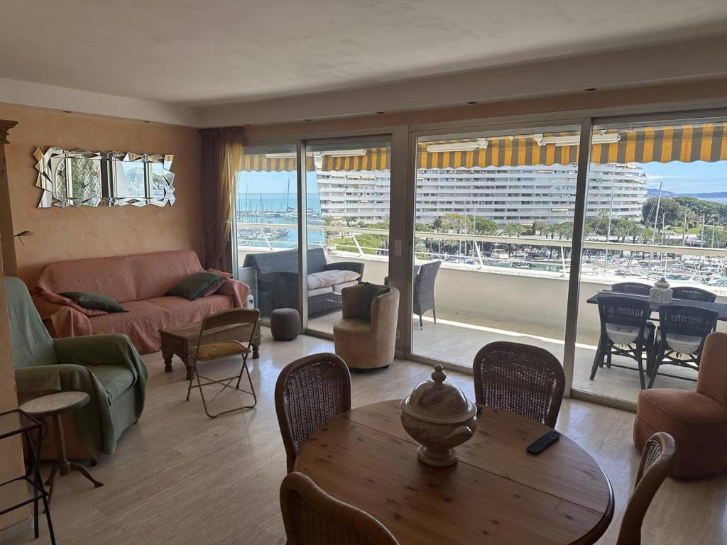 un salon avec un canapé et une table avec des chaises dans l'établissement Appartement spacieux avec terrasse vue port, parking inclus - FR-1-252A-133, à Villeneuve-Loubet