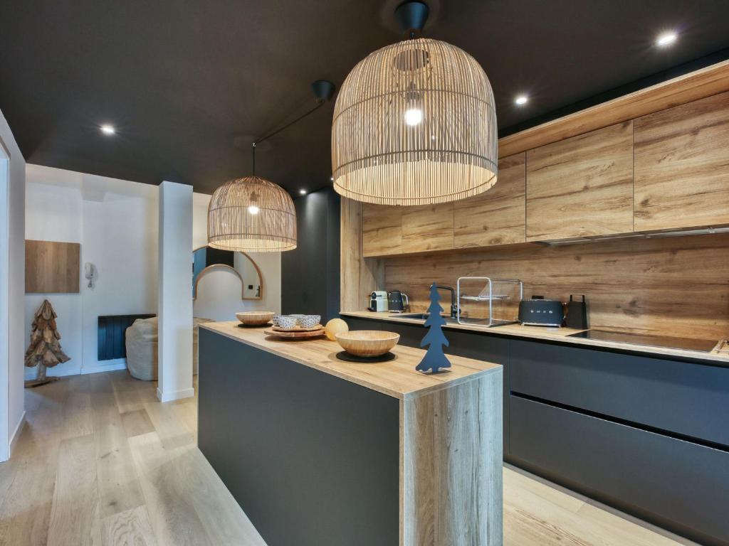 - une cuisine avec deux lampes suspendues et un comptoir dans l'établissement Appartement neuf 73m² centre Saint-Gervais, 2 chambres, parking, wifi - FR-1-663-44, à Saint-Gervais-les-Bains