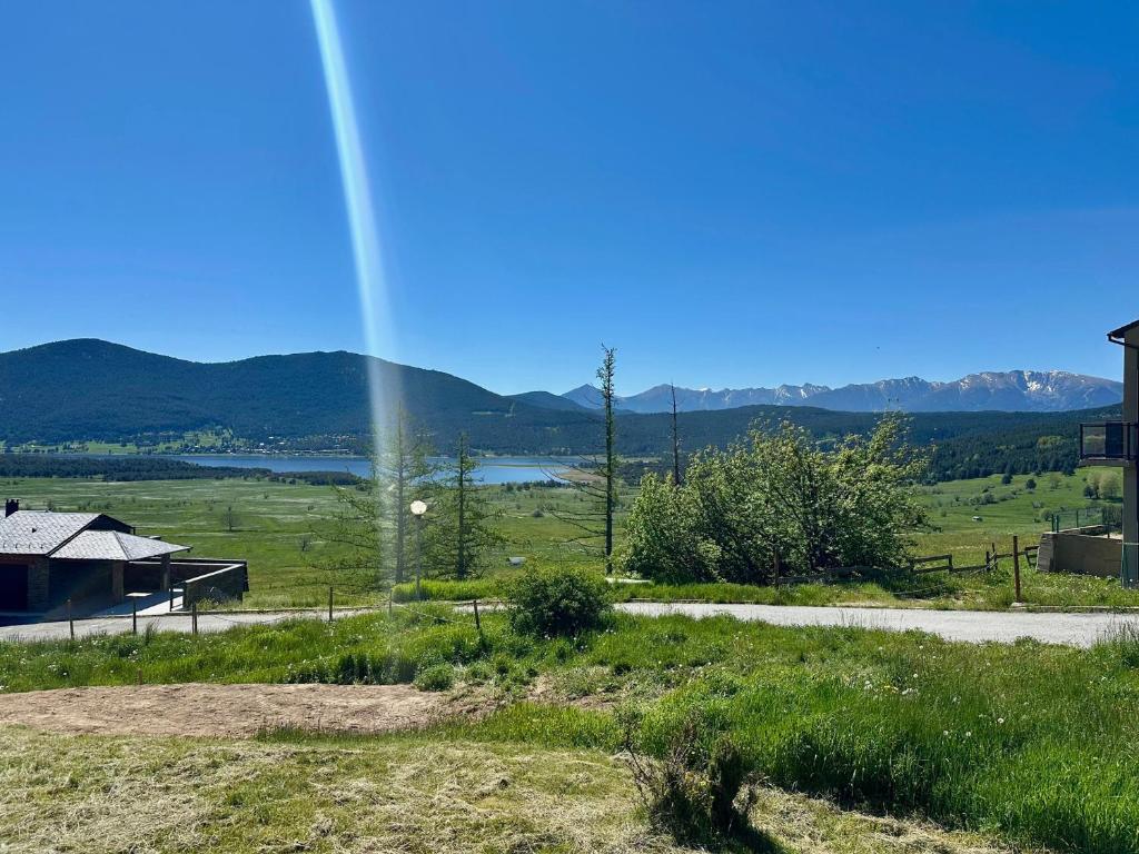 a rainbow over a field with a house and a road at Appartement T4 Duplex 60m², 6 Pers, Vue Lac & Montagnes - FR-1-758-40 in Les Angles