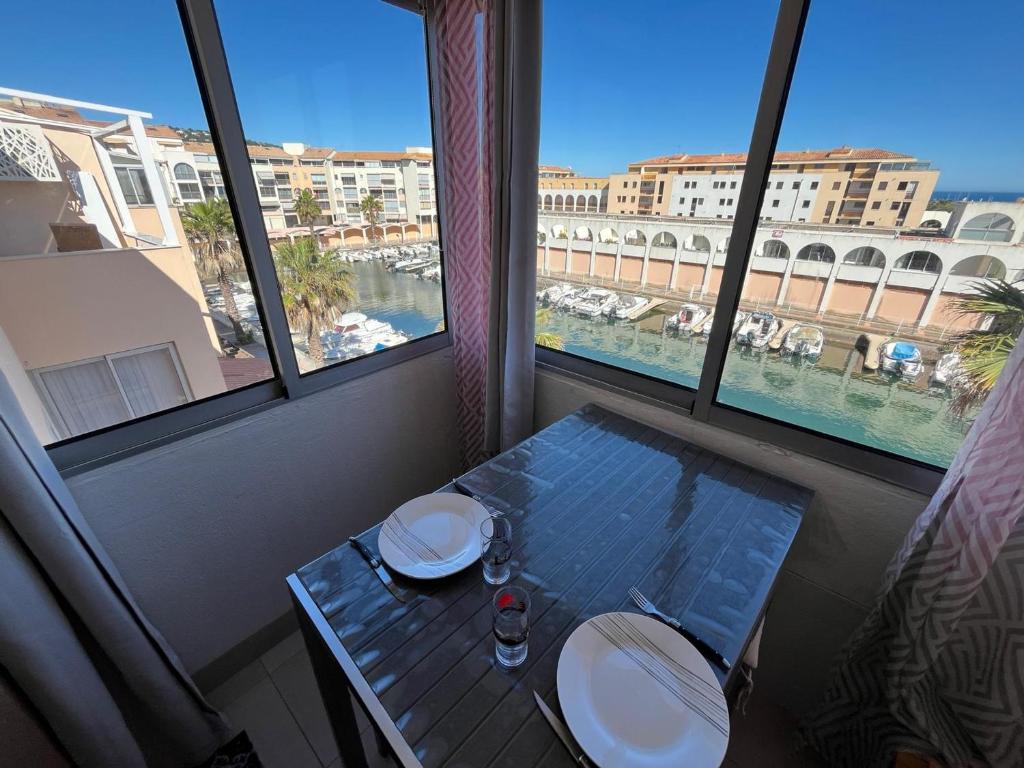 - une table dans une chambre avec vue sur le port dans l'établissement Appartement 2 pièces près de la plage avec mezzanine et parking - FR-1-338-621, à Sète