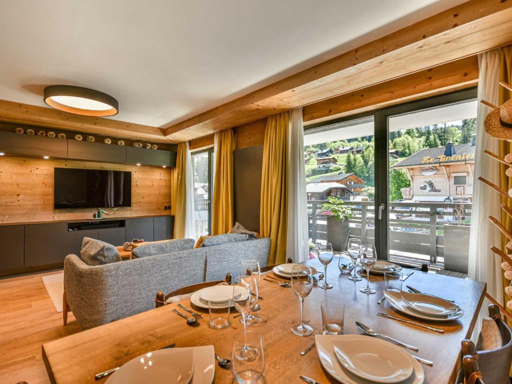 une salle à manger avec une table et un canapé dans l'établissement Chalet T4 spacieux 6-8 pers. avec vue sur les pistes - FR-1-685-88, aux Gets