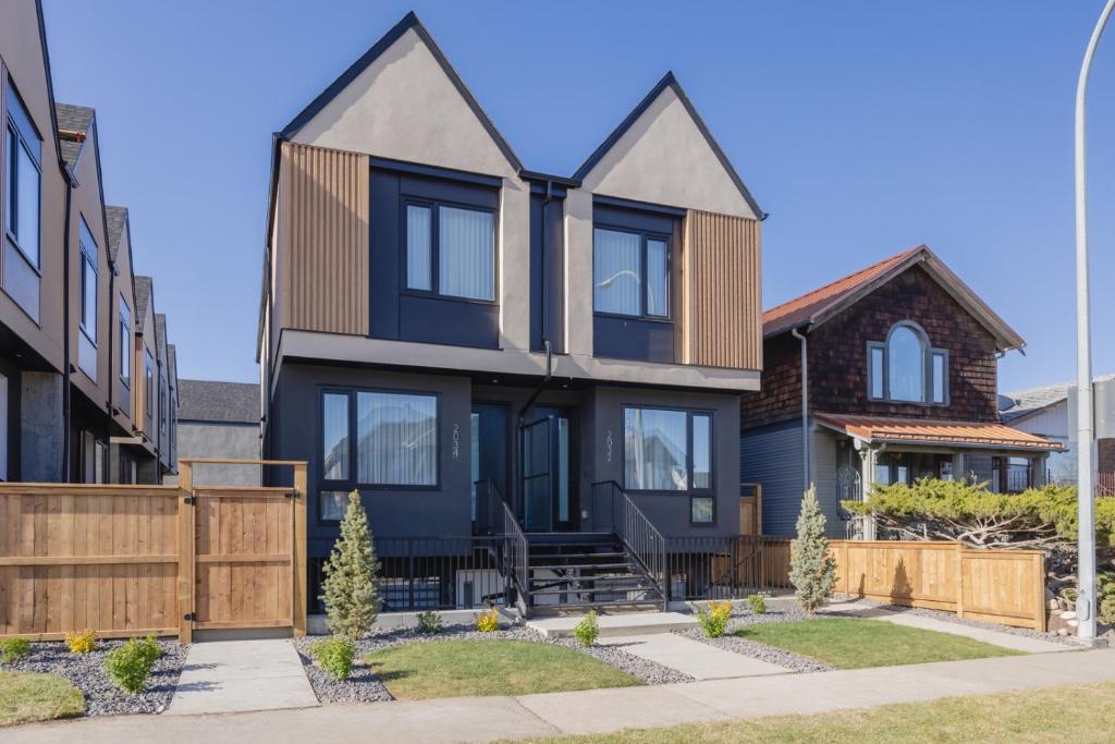 ein Haus mit schwarzen Fenstern und einem Holzzaun in der Unterkunft Fenced Yard, Free Parking, 2 King Beds with AC in Calgary