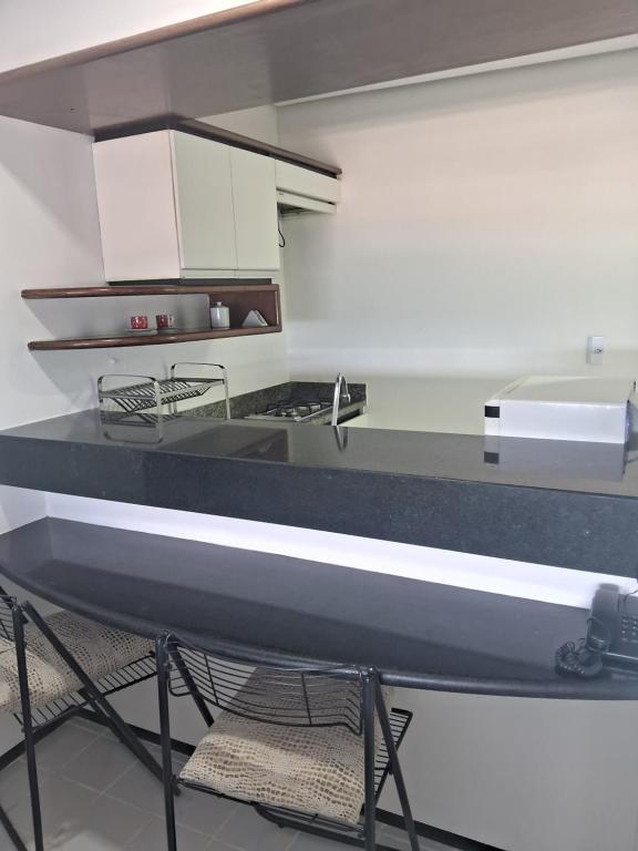 ジョアンペソアにあるHotel Tambau Flat particular908のキッチン(黒いカウンタートップ、白いキャビネット付)