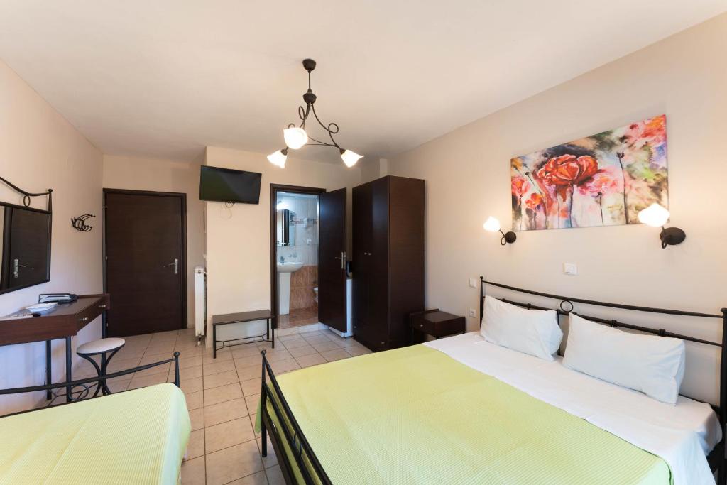 a hotel room with a bed and a desk at Kipos Resort in Nea Peramos