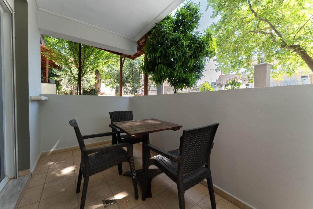 a table and chairs on a patio with trees at Kipos Resort in Nea Peramos
