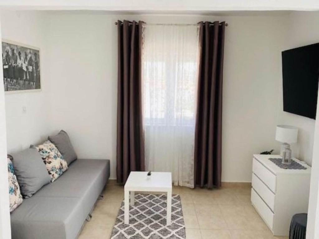 una sala de estar con un sofá y una mesa en Villa Brazza - Studio Apartment, en Milna