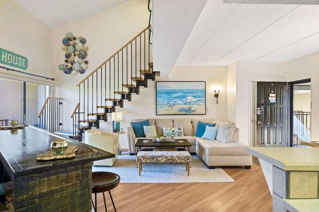 a living room with a staircase and a couch at Luxury Penthouse near Beach Tiki Hut Coligny in Hilton Head Island