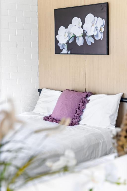 a bed with white sheets and a purple pillow at Quiet Crescent Stay in Liverpool - Comfortable Double Room - Shared Bathroom in Liverpool