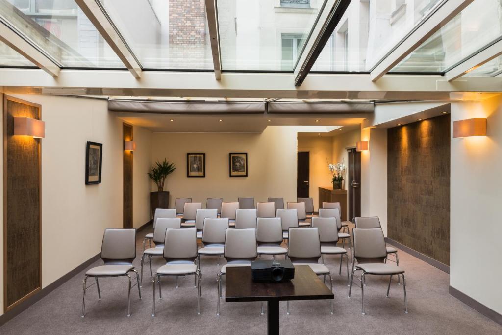 a conference room with chairs and tables and windows at Hôtel La Bourdonnais by Inwood Hotels in Paris