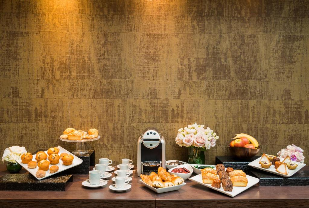 a table topped with plates of food and desserts at Hôtel La Bourdonnais by Inwood Hotels in Paris