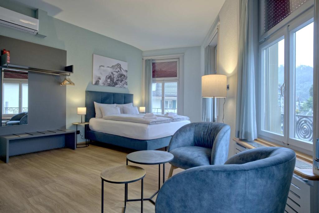 a hotel room with a bed and two chairs at BANK House Studio L 205 - GRIWA RENT in Interlaken