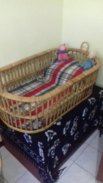 a basket with a blanket on top of a bed at Homestay Galpera Papua in Jayapura