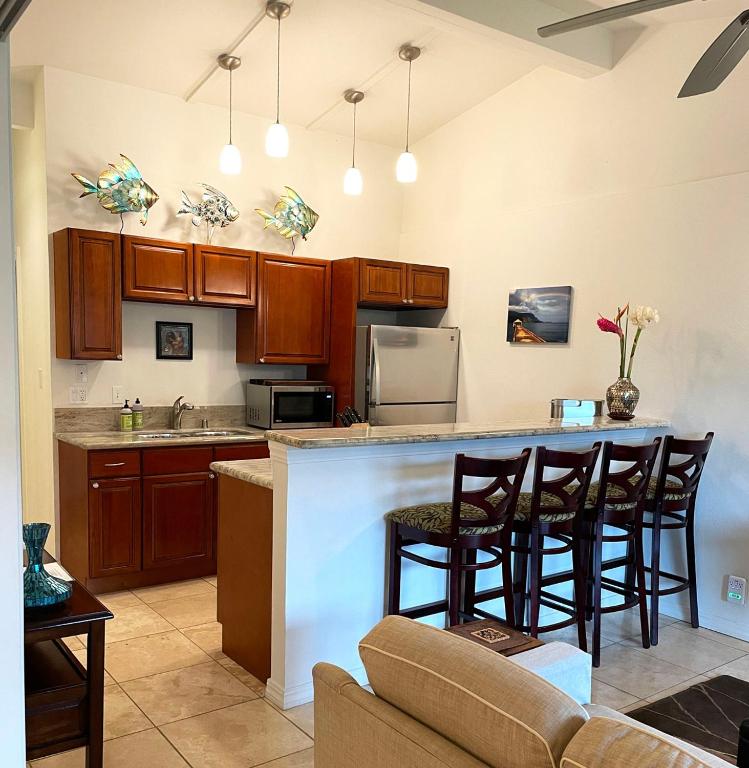 a kitchen with a bar with stools at Kauai Getaway Condo in Kapaa