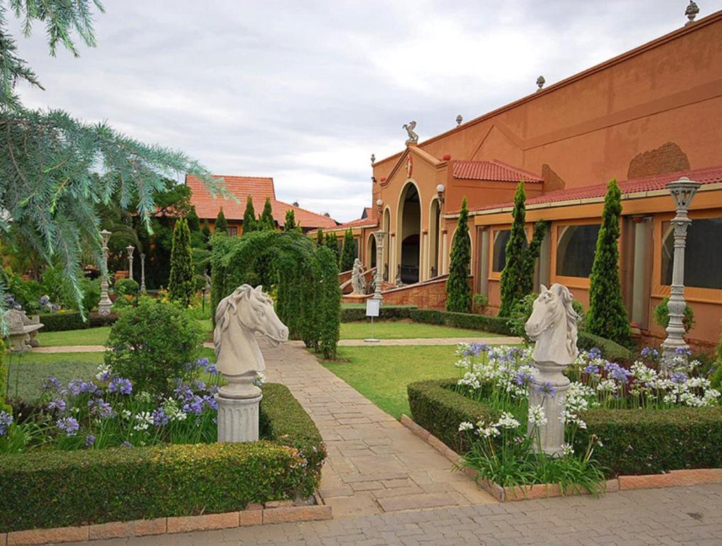 zwei Statuen in einem Garten vor einem Gebäude in der Unterkunft Midrand Conference Centre in Midrand