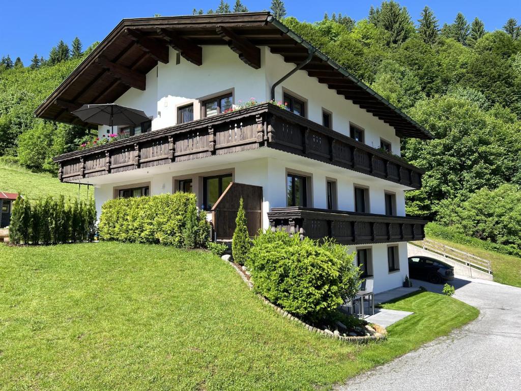 a house on a hill with a green yard at Appartement Maria Theresia in Hopfgarten im Brixental