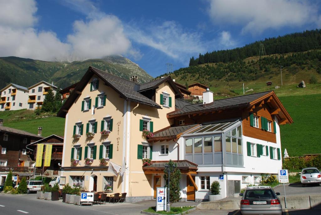
a small town with a house on the side of the road at Hotel Posta in Sedrun
