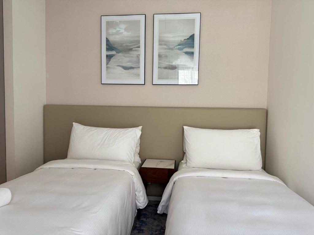 two beds sitting next to each other in a room at Address Beach Resort Fujairah Apartment by Blue World - 2 in Fujairah