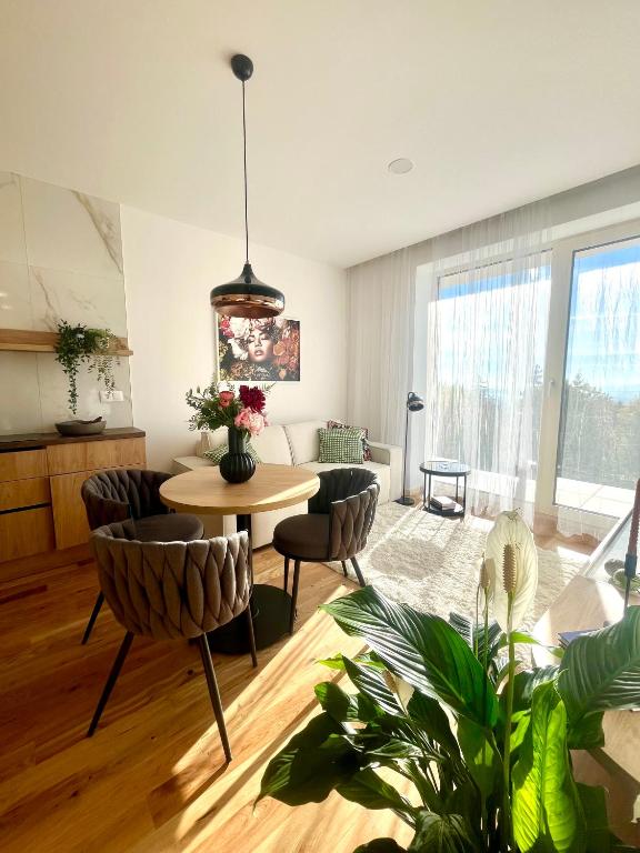 a living room with a table and chairs at Apartmán PLÁŇ Vesna Resort in Vysoké Tatry
