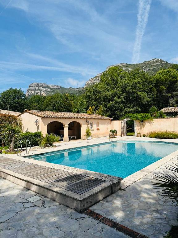 - une piscine avec une passerelle en bois à côté d'une maison dans l'établissement Hacienda Provençale- Piscine, Pétanque et Plenitude, à Saint-Jeannet