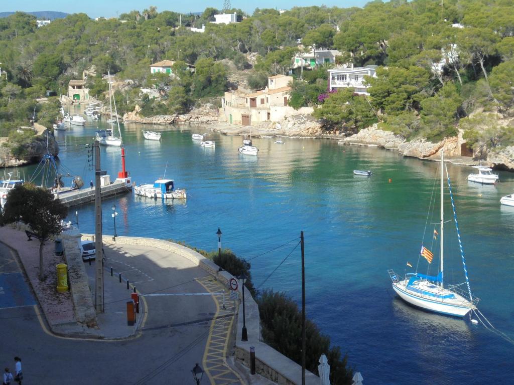 a boat is docked in a river with other boats at Hostal Can Jordi in Cala Figuera