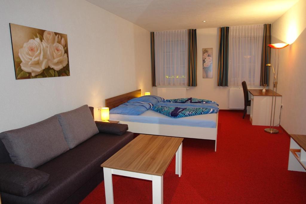 salon z łóżkiem i kanapą w obiekcie Hotel Garni Daniela Urich w mieście Schwanenstadt