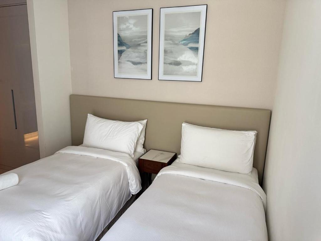two beds sitting next to each other in a room at Address Beach Resort Fujairah Apartment by Blue World - 3 in Fujairah